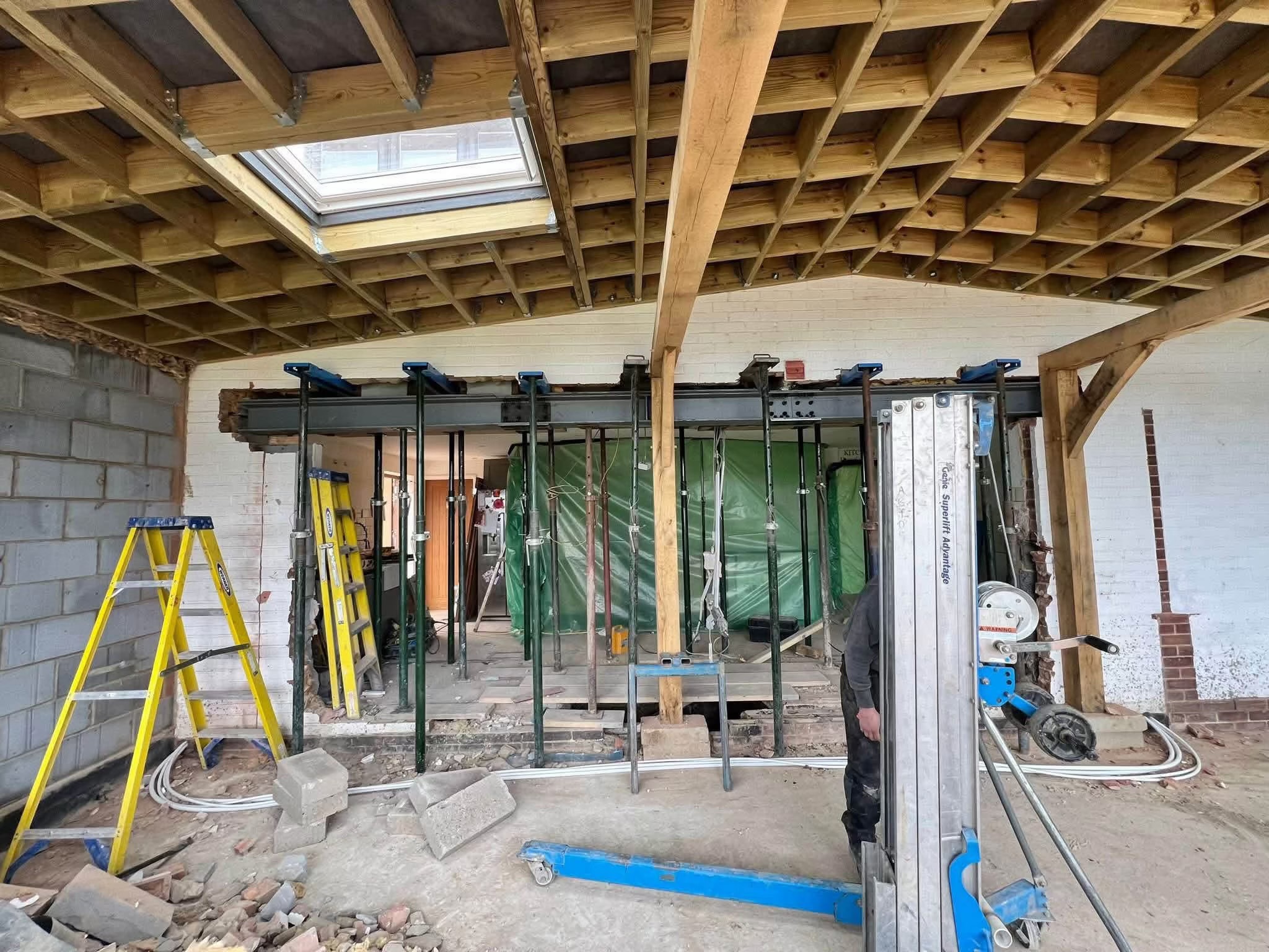 Steel beam, temporary supports and timber roof framing during building work