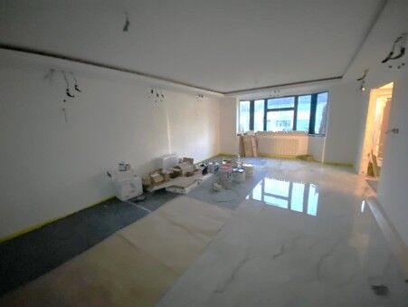 Large polished marble-effect floor tiles laid across an open-plan room