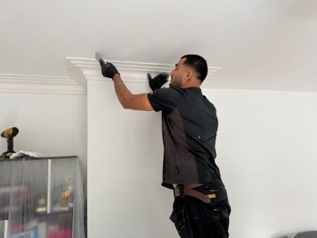 Tradesman fitting decorative coving in a renovated room