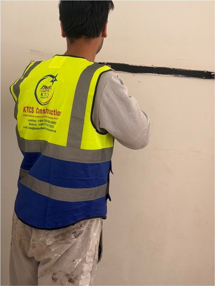 KTCS decorator painting a crisp dark line on a wall