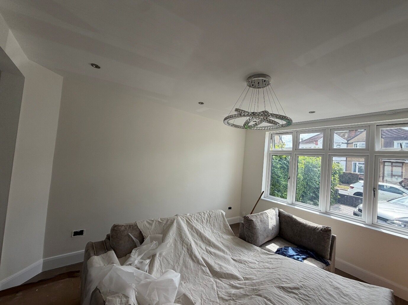 Freshly painted living room with a chandelier and bay window