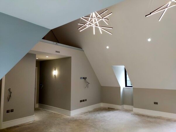 Freshly painted loft room with angled ceilings and modern lighting