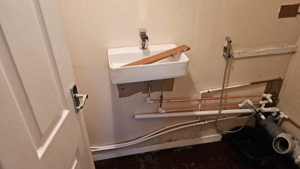 New basin plumbing with copper and waste pipework in a cloakroom
